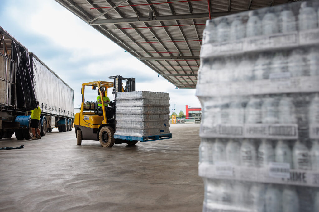 103 BRIFeb2024 4399 BRi warehouse team coordinating a forklift loading pallets during peak-season stock movement